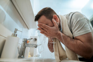 hombre lavandose la cara con jabones essential soap